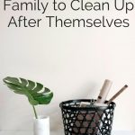 The words "How to get your Family to Clean Up After Themselves" over a basket of pens and a small green leaf planter 