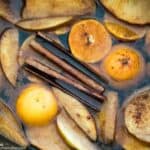 apple and orange slices with cinnamon in water