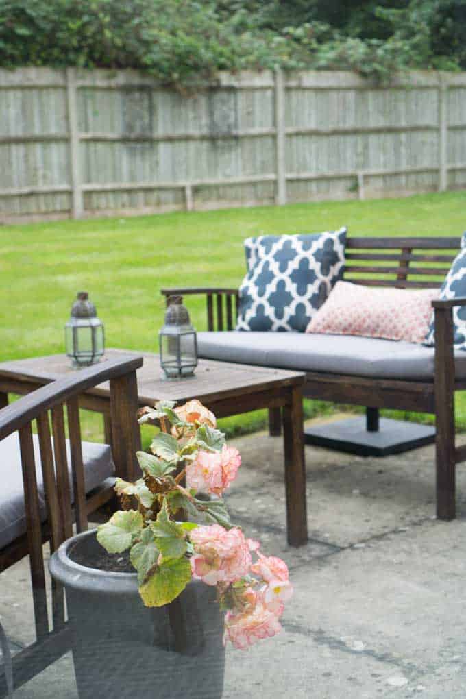 An outdoor furniture set with different pillows and candle holders