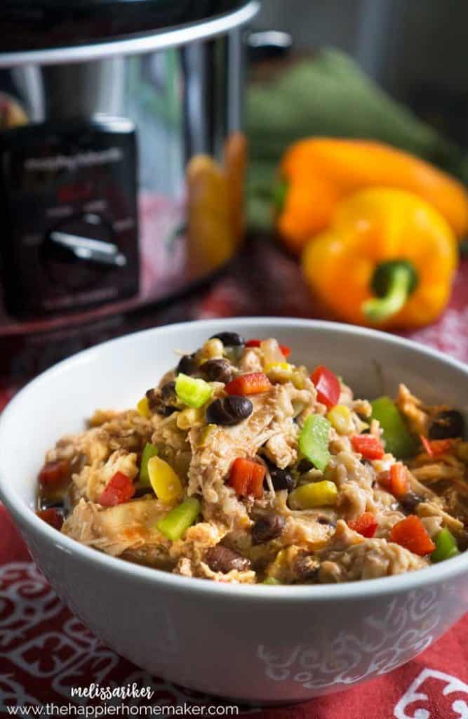 A close up of Mexican flavored chicken with orange peppers in the background