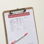 a piece of paper titled "Freezer Inventory" on a clipboard with a pen on it