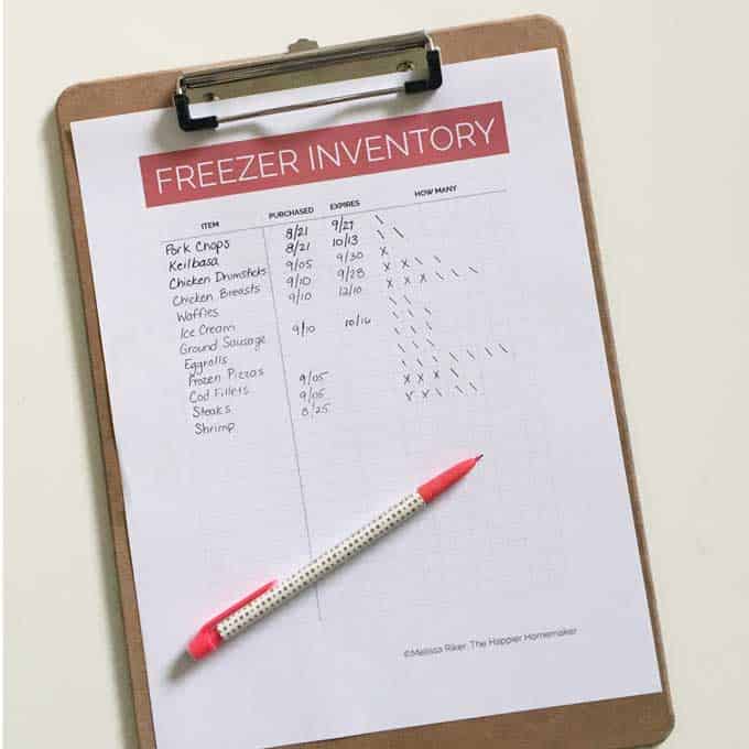 A piece of paper titled "Freezer Inventory" on a clip board with a pen