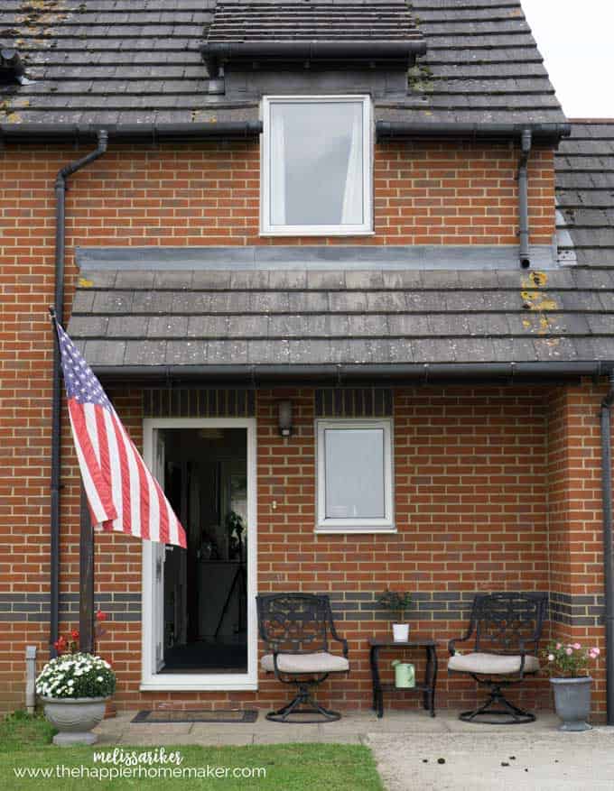 An American flag flying outside of a red brick home located in England