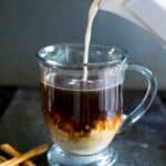 creamer pouring into glass of coffee
