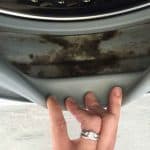 hand holding dirty washing machine seal open