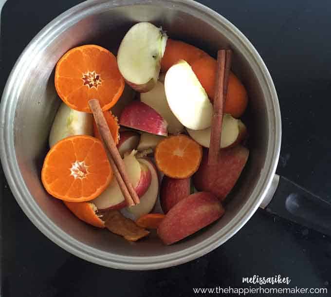 pot of sliced oranges, apples, and cinnamon sticks
