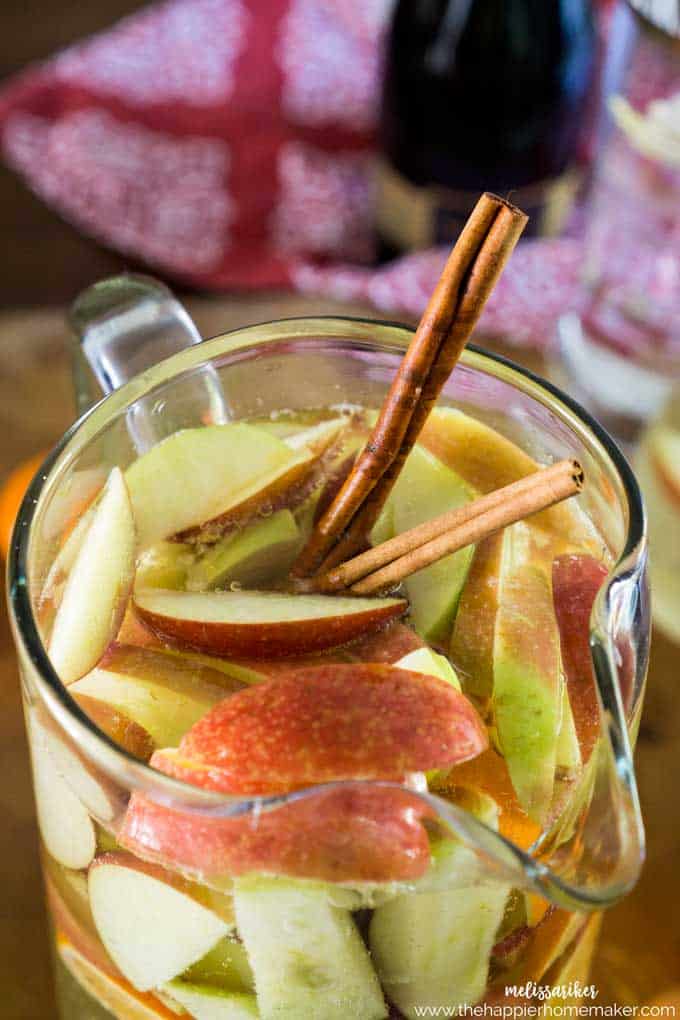 A close up of a pitcher full of apple pie Sangria