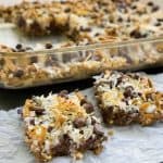 A close up of two pretzel caramel bars with chocolate chips and coconut