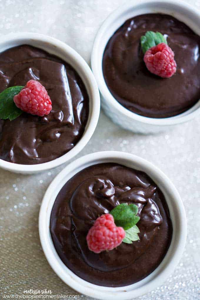 bowls of chocolate mousse topped with a raspberry