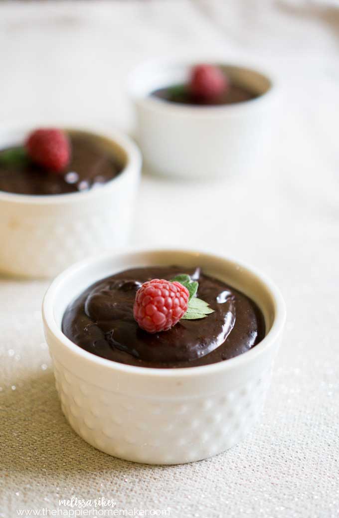 bowls of chocolate mousse topped with raspberry