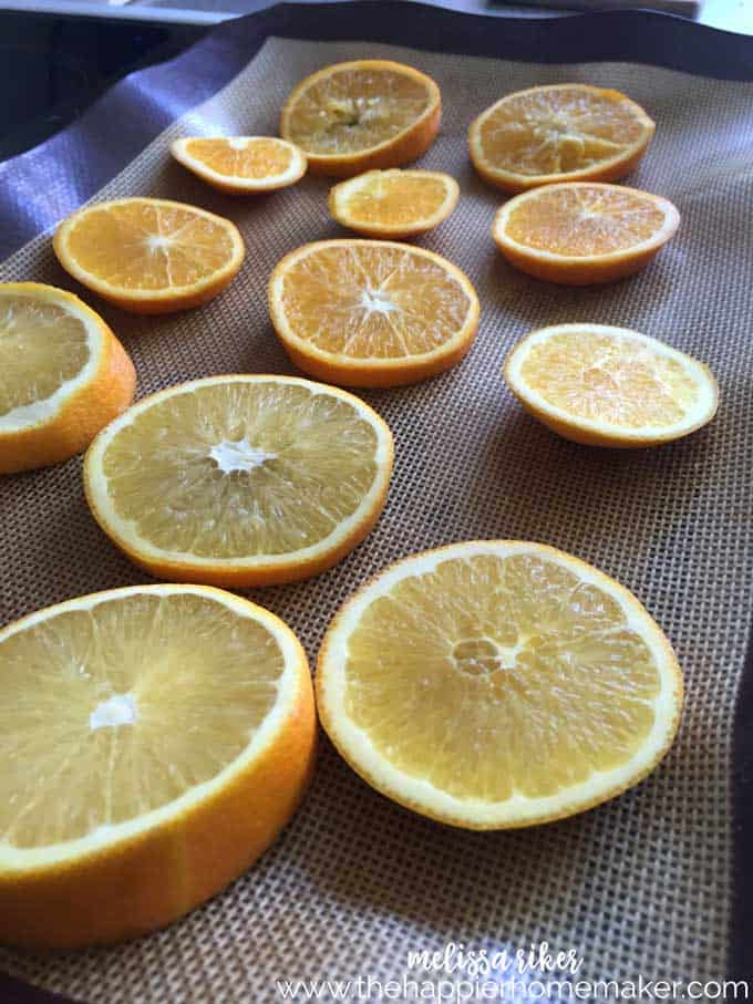 Several sliced oranges before baking on an oven sheet