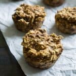 A close up of four healthy low fat apple oatmeal muffins before baking on white paper