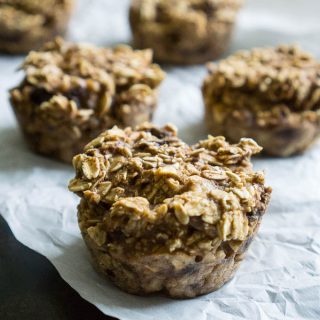 A close up of five healthy low fat apple oatmeal muffins before baking on white paper