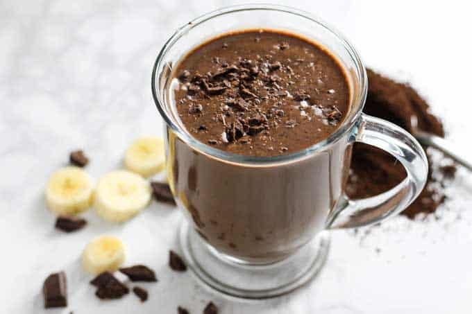 chocolate coffee smoothie on a table with Chocolate and banana slices