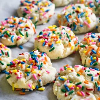 close up of funfetti cookies with colorful sprinkleson parchment paper