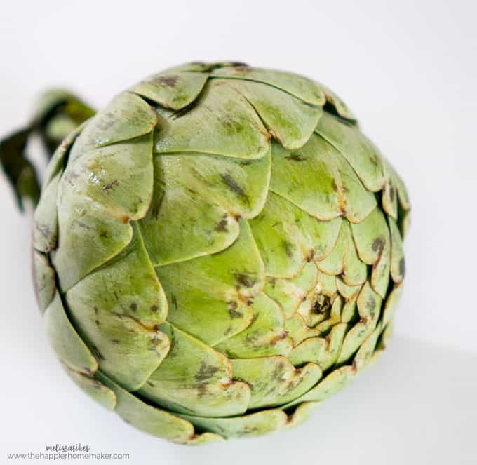 A close up of an artichoke on a white table