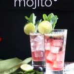 Two blueberry mojitos garnished with limes