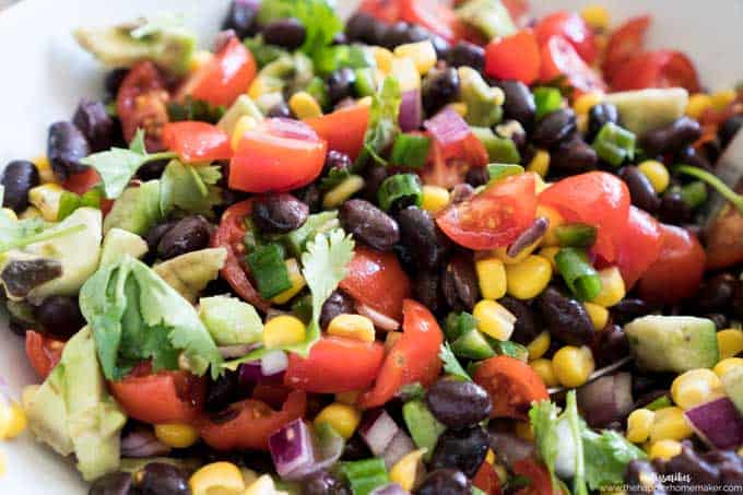A close up of cowboy caviar made of black beans, corn salad, cilantro and lime