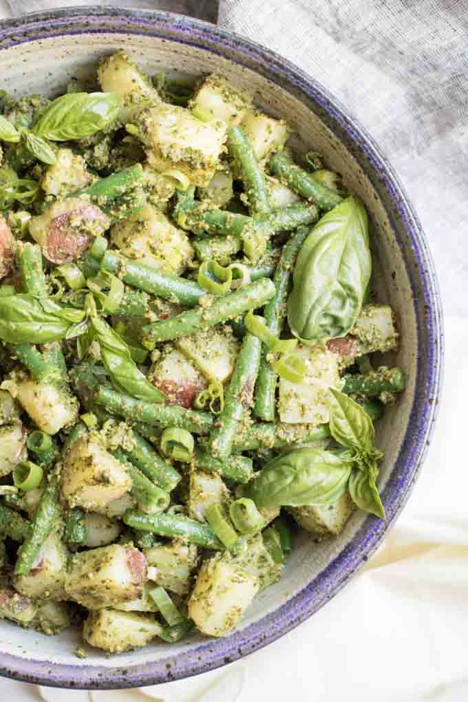 A close up of pesto potato salad with green beans.