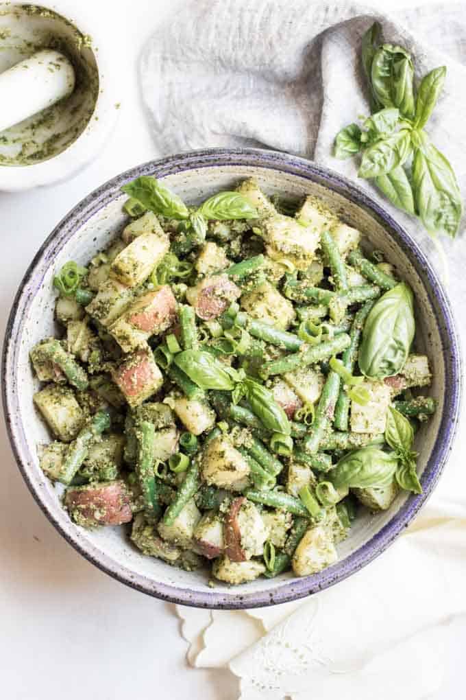 A bowl of pesto potato salad with green beans.