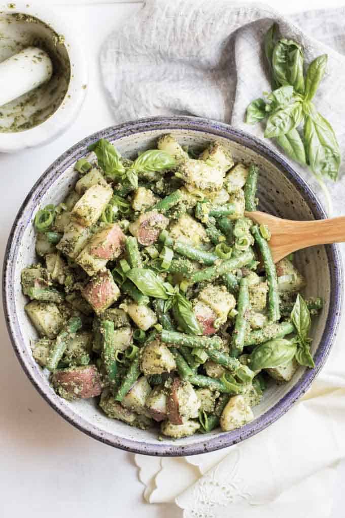 A close up of pesto potato salad with green beans.