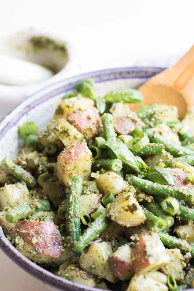 A close up of pesto potato salad with green beans.