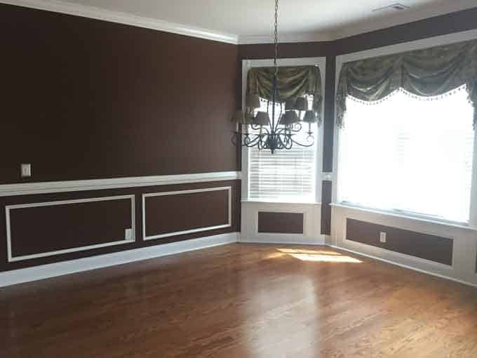 A large empty dining room with maroon paint