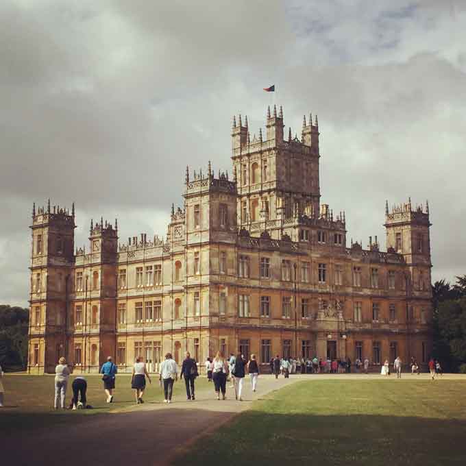 A large clock tower towering over Highclere Castle