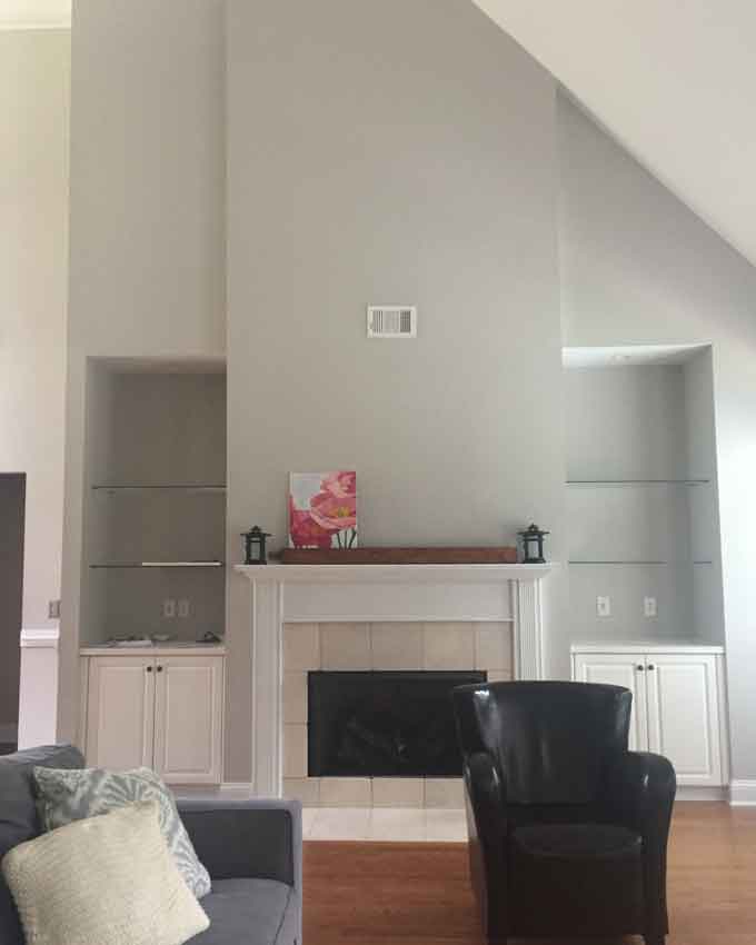 A living room after repainting the walls with a sofa and leather chair in it.