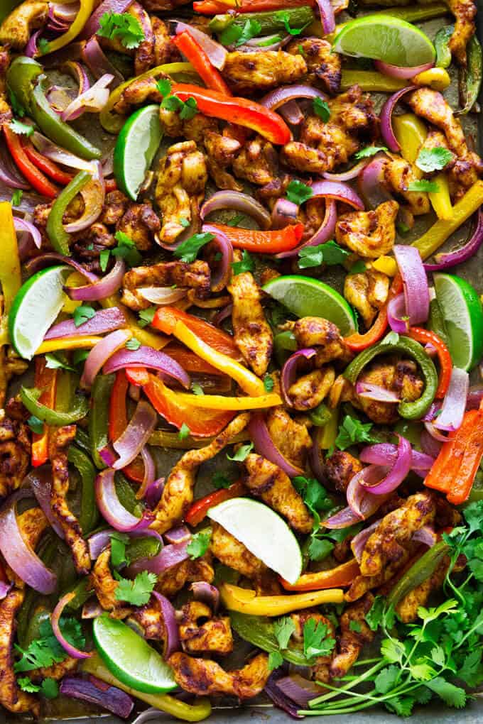 Cooked pan roasted chicken fajitas with cilantro lime sauce with red and yellow peppers and onion.