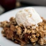 A close up of apple oatmeal crisp with ice cream on top
