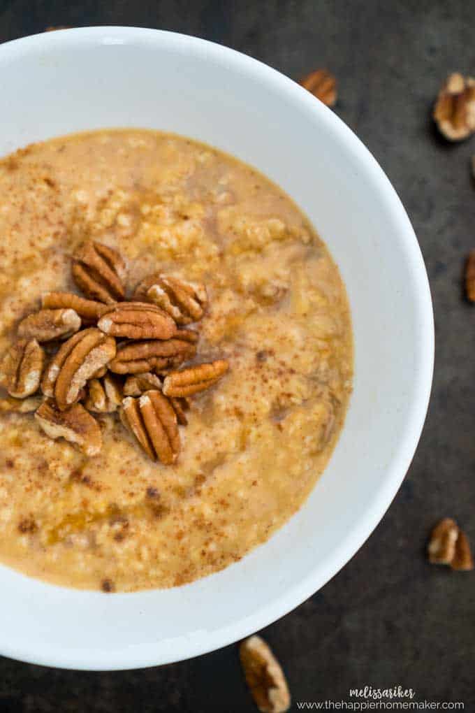 close up of a bowl of pumpkin oatmeal topped with pecans