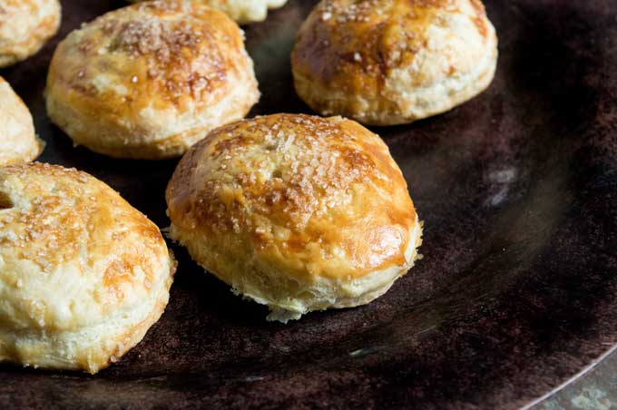 close up of apple hand pies on black baking sheet