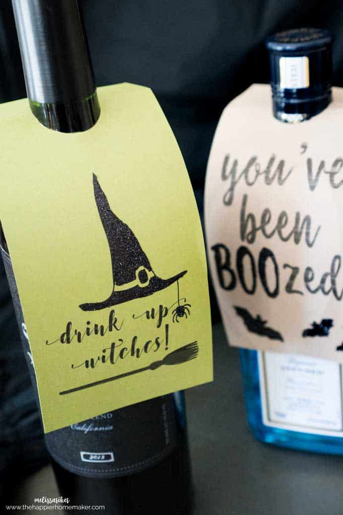 A close up of wine bottles with tags reading drink up witches and you've been boozed