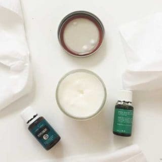 overhead view of coconut oil in a jar with bottles of essential oils