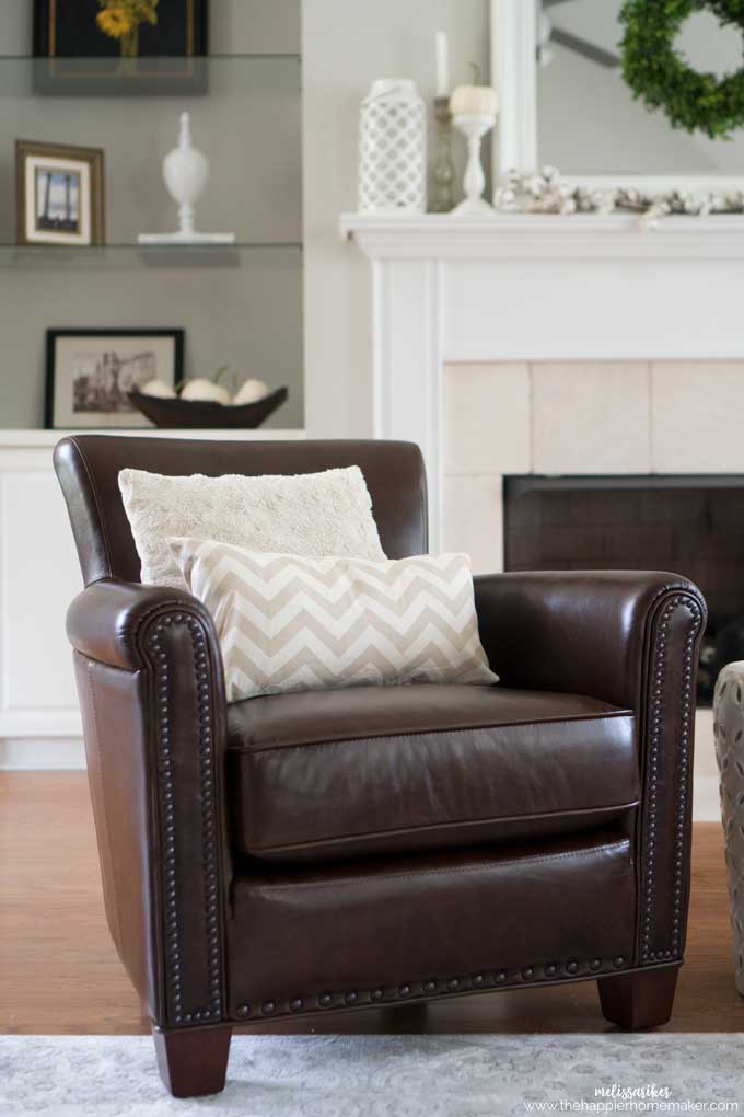 A living room with a leather chair with two throw pillows