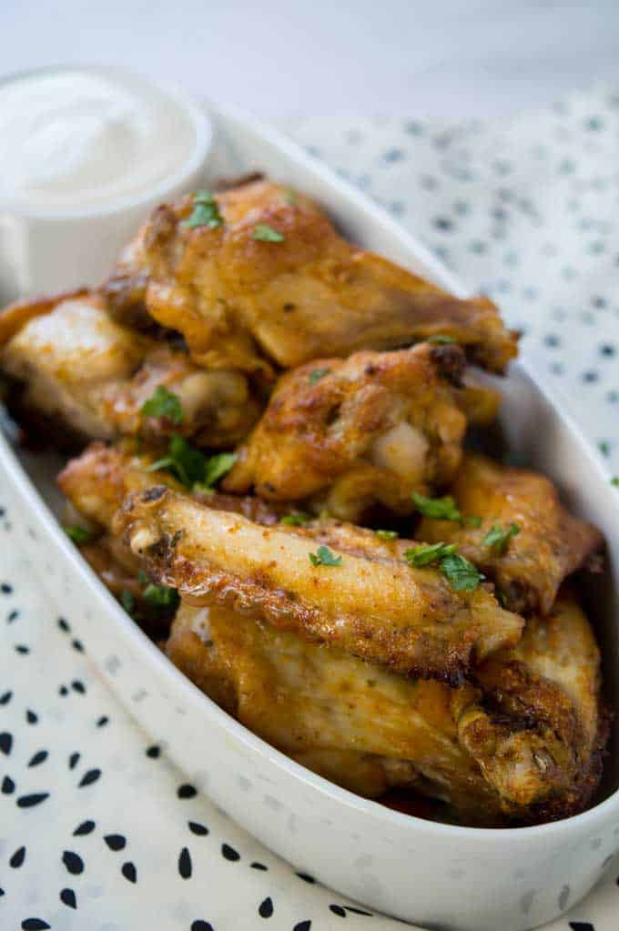 A close up of taco ranch chicken wings with green garnish