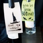 A close up of wine bottle and liquor bottle with tags reading drink up witches and you've been boozed