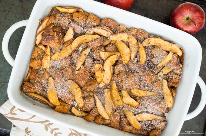 Apple Baked French Toast in white dish with red apples and napkin