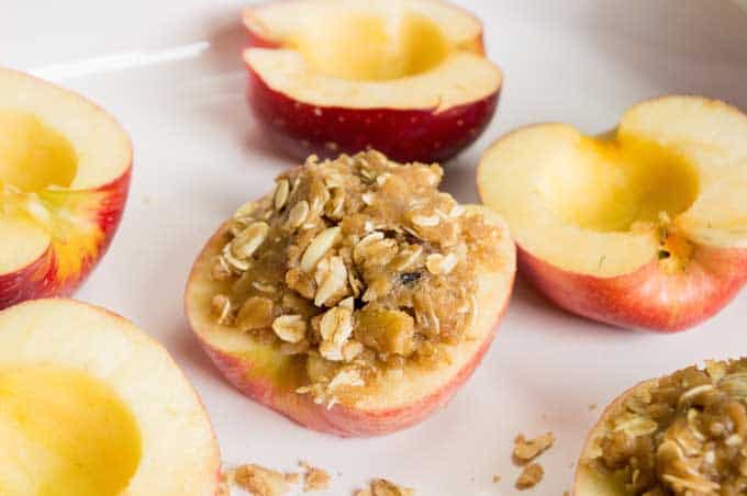 Apples sliced in half with oatmeal crisp topping inside