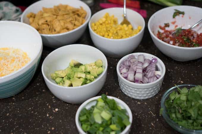 The ingredients consisting of corn, onion, green onion, avocado for chili in separate bowls