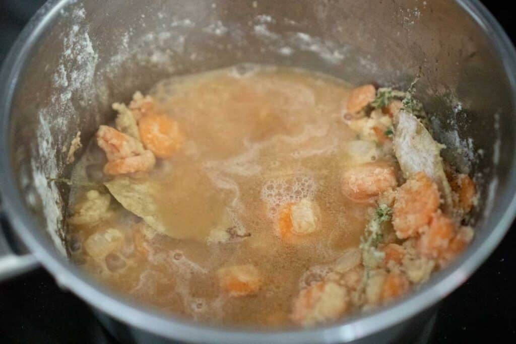 simmering gravy in pot with vegetables