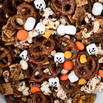 halloween snack mix with pretzels, mini marshmallows that look like skulls, and M&Ms