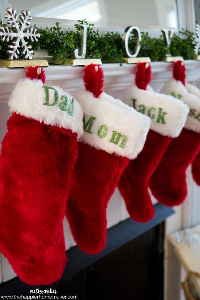 A close up of four stockings hanging from a mantle