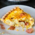 pice of bacon cheddar quiche on white plate