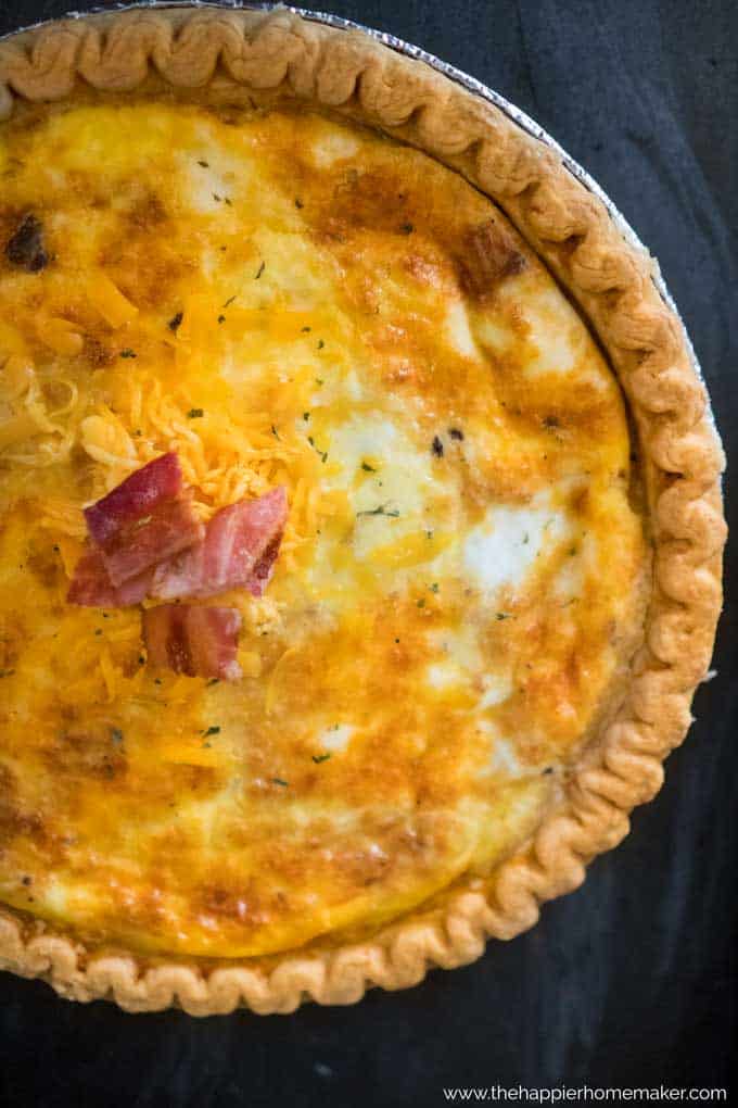 A close up a baked quiche garnished with bacon