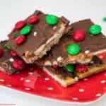 Saltine cracker toffee with red and green M&Ms on a red plate