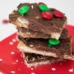 stack of christmas crack saltine toffee on red plate
