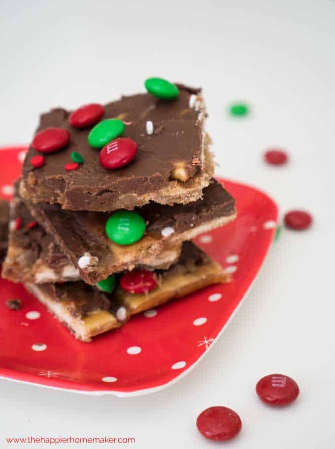 A close up of saltine cracker toffee with red and green M&Ms