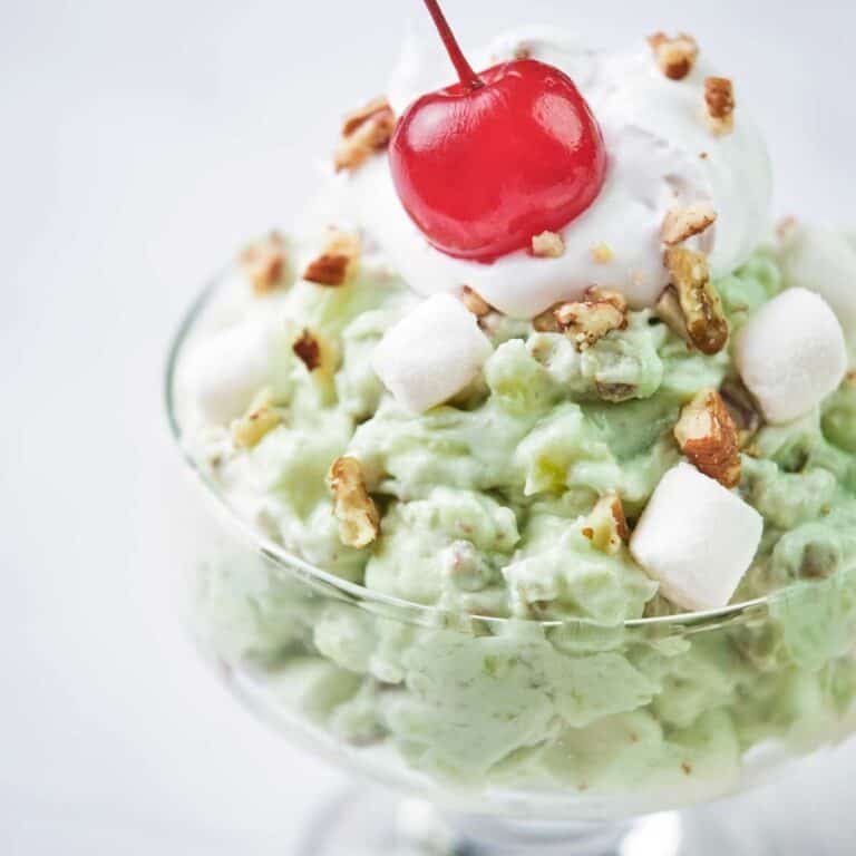 close up of watergate salad topped with maraschino cherry in a glass dish